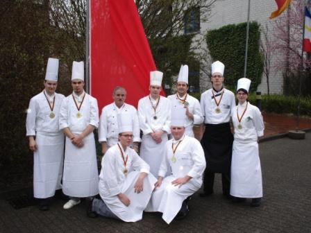 Die Teilnehmer der 4 Mannschaften des zweiten Wettkampftages mit dem Vorsitzenden des Köchevereins Fischland-Darß e.V. Hans Martens, Top-Ausbilder des Jahres 2007 (3. v. l.), vor der Fahne des Hauptsponsors des Wettbewerbs um den Küstenfischpokal, der Sparkasse Vorpommern. Foto: Eckart Kreitlow